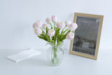 White and pink faux tulip stems in a small ruffled glass vase
