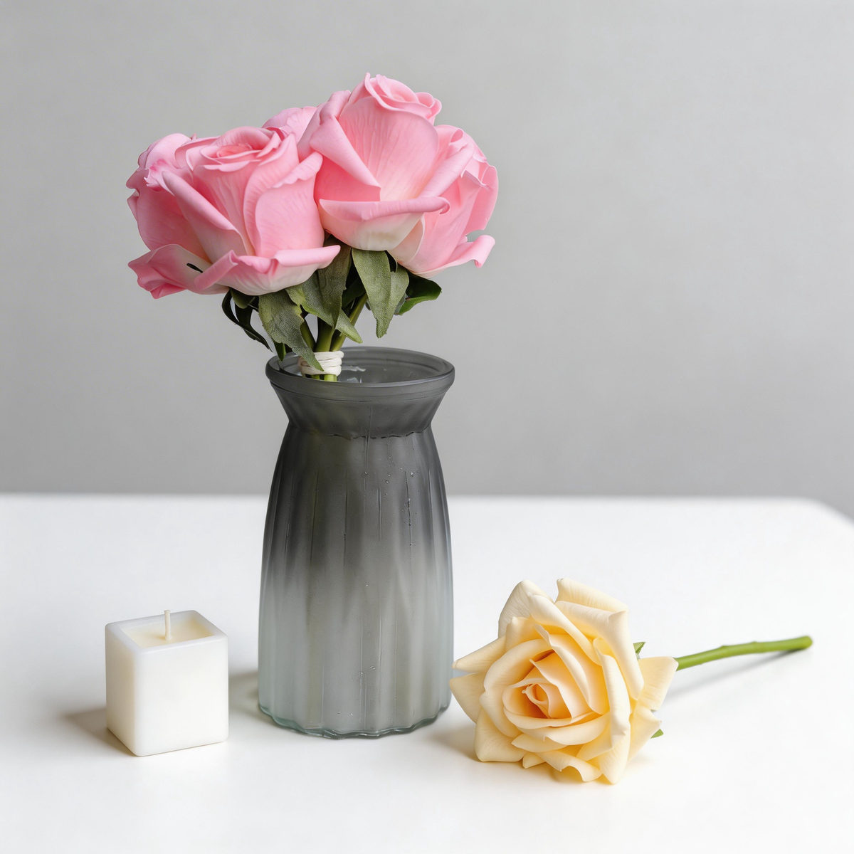 Pink and cream faux roses styled with a frosted grey vase