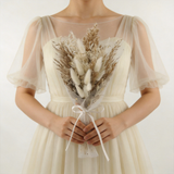 Neutral dried bouquet with bunny tails and oat grass in sheer white tulle