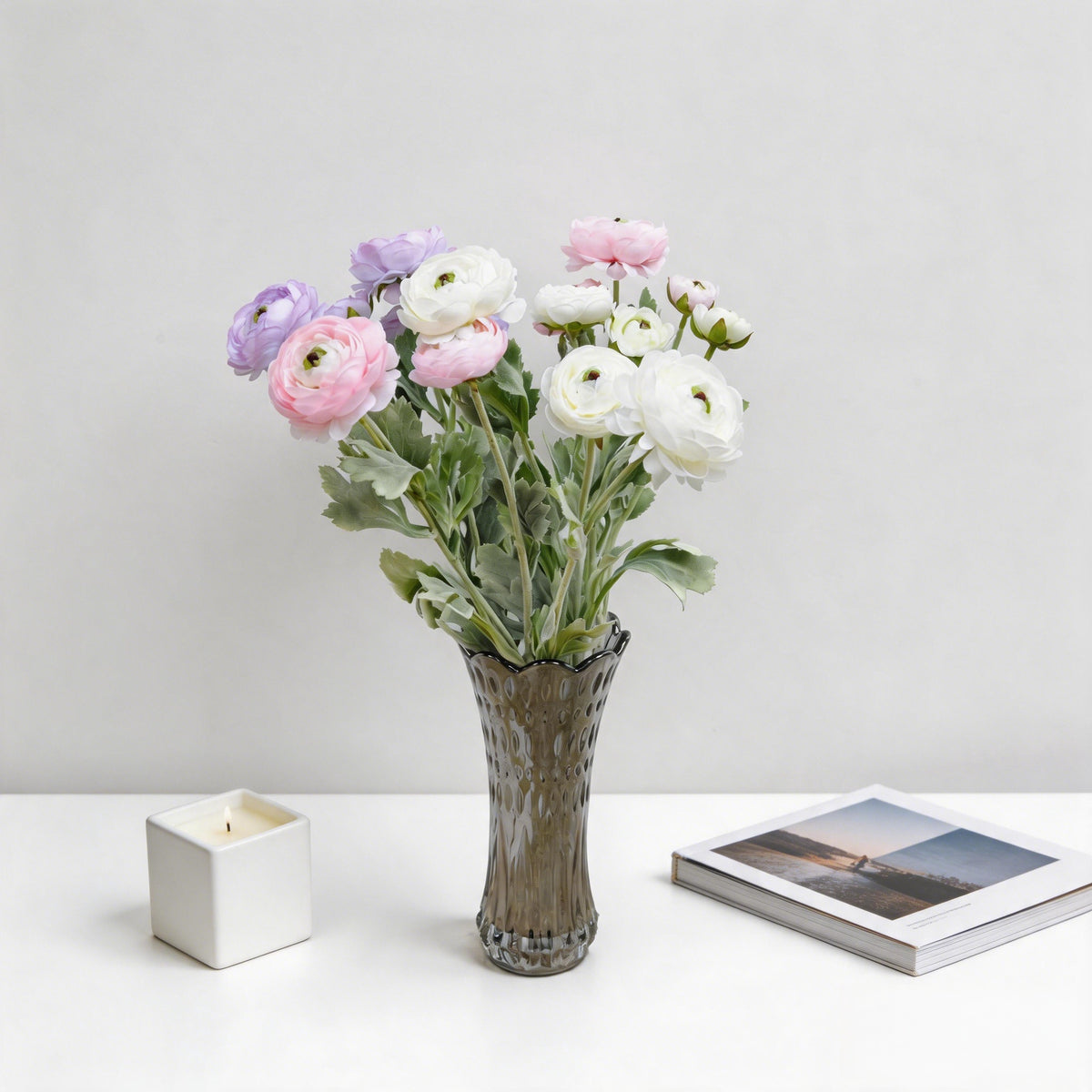 Faux ranunculus spray with tightly layered petals and small buds in a fluted vase