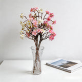 Faux cherry blossom branches with pink and white blooms on woody brown stems